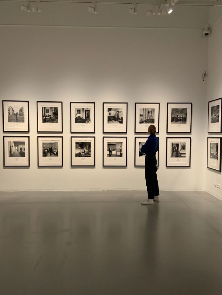 Une personne admirant des photos sur un lieu d'exposition