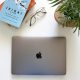 Livre Ikigai posé sur un bureau avec un MacBook et une plante verte