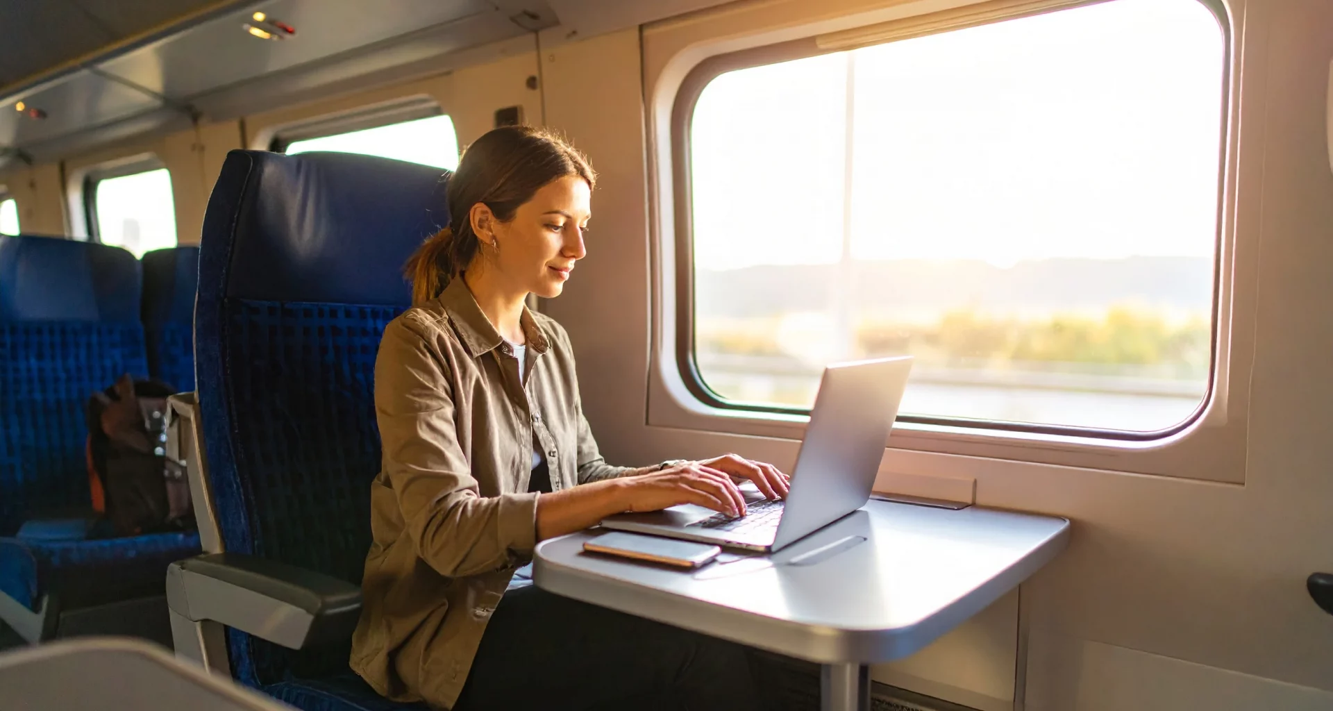 Femme utilisant un MacBook Air M4 dans un train, parfait pour travailler en mobilité